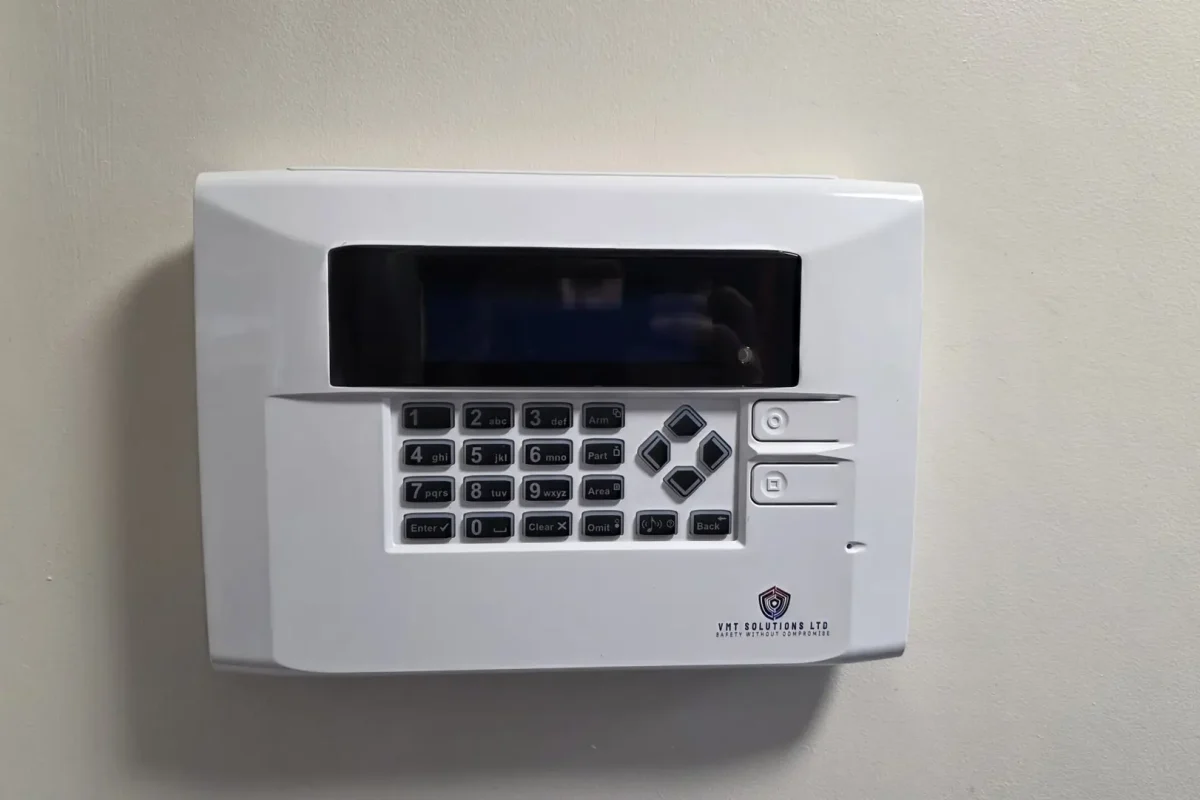 Engineer testing an intruder alarm system as part of professional installation standards